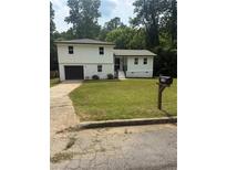 Charming two-story home with a well-manicured lawn and a convenient attached garage at 9148 Homewood Dr, Riverdale, GA 30274