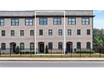 Charming brick townhome with a wrought iron fence and well-maintained landscaping at 3334 Swallowtail Ter, Duluth, GA 30096