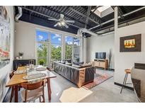 Bright living room with large windows, open ceiling, and a dining area, creating a spacious loft-style apartment at 5200 Peachtree Rd # 3420, Atlanta, GA 30341