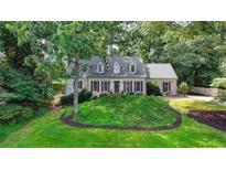 Charming single-story home with beautiful landscaping, featuring a classic brick facade and mature trees at 5285 Bannergate Dr, Johns Creek, GA 30022