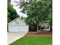 Charming one-story home with a two-car garage, mature trees, and well-maintained lawn at 1003 River Plantation Dr, Woodstock, GA 30188