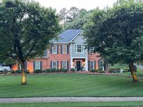 Charming brick home with manicured lawn and inviting front porch featuring rocking chairs at 3532 W Hampton Nw Dr, Marietta, GA 30064