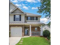 Charming two-story home featuring a brick facade, covered porch, and well-maintained lawn at 417 Red Coat Ln, Woodstock, GA 30188