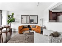 Bright living room featuring an orange sofa, neutral rug, and modern decor elements at 620 Peachtree Ne St # 1206, Atlanta, GA 30308