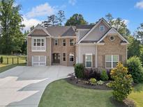 Charming two-story brick home with a well-manicured lawn and an attached two-car garage at 2385 Saddle Brook Trce, Cumming, GA 30040