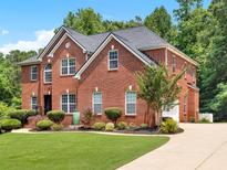Beautiful two-story brick home with a well-manicured lawn and mature landscaping at 2725 Bailey Ne Pl, Conyers, GA 30013