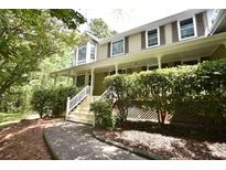 Charming home featuring a welcoming front porch, complemented by lush landscaping and well-maintained stairs at 4162 Riverdale Dr, Snellville, GA 30039