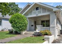 Charming white brick home with a well-manicured lawn and lush landscaping at 504 Angier Ne Ave, Atlanta, GA 30308