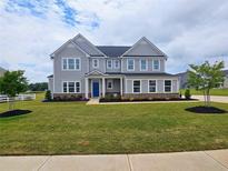 Charming two-story home with gray siding, a blue front door, and a well-manicured lawn at 105 Marchmont Dr, Locust Grove, GA 30248