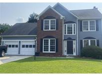 Charming two-story home with a well-maintained lawn and attached two car garage at 2994 Abbotts Oak Way, Duluth, GA 30097