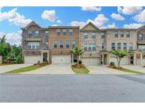 Attractive townhouse exteriors featuring brick facade, garages, driveways, and tidy landscaping at 3587 Hidden Valley Cir, Lawrenceville, GA 30044