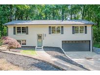 Charming home featuring painted brick, a well-manicured lawn, and an attached garage at 2825 Shea Sw Way, Marietta, GA 30060