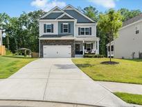 Charming two-story home with stone accents, attached garage, manicured lawn, and welcoming front porch at 340 Louise Ln, Canton, GA 30114