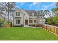 Charming two-story white home with a lush green lawn, fenced yard, and beautiful landscaping at 4250 Summit Dr, Marietta, GA 30068