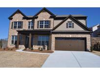 Charming two-story brick home features a manicured lawn and a two-car garage with an extended driveway at 920 Crescent Ridge Dr, Buford, GA 30518