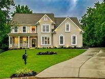 Charming two-story home with a well-manicured lawn and inviting front porch at 365 Morning Dew Cir, Roswell, GA 30075