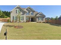 Charming two-story home featuring a manicured lawn, gray siding, black shutters, and a brick-accented porch at 7820 Longview Dr, Cumming, GA 30041