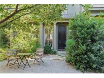 Charming home featuring a cozy outdoor seating area surrounded by lush greenery and a black front door at 2196 Niles Ne Pl, Atlanta, GA 30324