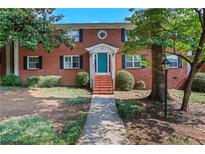 Charming brick home featuring a well-manicured lawn, colorful teal door and a welcoming facade at 4282 Roswell Ne Rd # K3, Atlanta, GA 30342