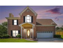 Charming brick home featuring a well-manicured lawn, covered entryway and attached two-car garage at 2928 Riverset Ct, Decatur, GA 30034