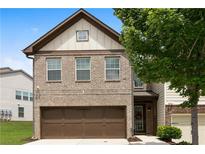 Charming two-story home with brick facade and a two-car garage, complemented by mature trees at 7628 Summer Berry Ln, Lithonia, GA 30038