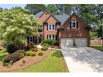 Charming brick home with a lush landscaped front yard and a two-car garage at 809 Hillcrest Ln, Woodstock, GA 30189