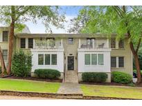 Charming brick building featuring symmetrical design, white trim, balconies, and lush greenery in a serene neighborhood setting at 1879 Johnson Ne Rd # 10, Atlanta, GA 30306