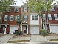 Brick townhouse with a front entrance, garage, and neatly maintained landscaping at 2104 Meadow Peak Rd, Duluth, GA 30097