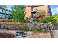 Apartment building with brick facade, blooming wisteria, and exterior stairs to upper units at 1705 Monroe Ne Dr # D05, Atlanta, GA 30324