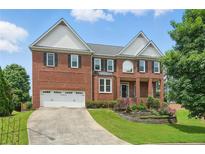 Stately two-story brick home with manicured lawn, two-car garage, and well-maintained landscaping at 2802 Arabian Ne Trl, Marietta, GA 30062