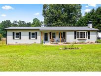 Charming single-story home featuring white brick, black shutters and a well-maintained lawn at 2905 Jim Owens Nw Rd, Kennesaw, GA 30152