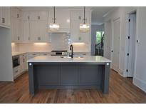 A spacious kitchen features a large island with a white countertop and modern lighting fixtures at 297 White St # 1, Marietta, GA 30060