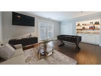 Inviting living room with a modern wet bar, foosball table, and sleek entertainment center at 13 Ivy Ne Sq, Atlanta, GA 30342