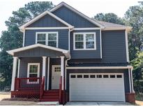Charming two-story home featuring a covered porch, attached garage, and modern architectural details at 102 Neal Ave, Stockbridge, GA 30281