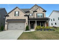 Charming two-story brick home with a well-manicured lawn and a two-car garage at 442 Snow Owl Way, Lawrenceville, GA 30044