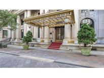 Grand building entrance featuring stately columns, intricate metalwork, and manicured greenery at 75 Ponce De Leon Ne Ave # 403, Atlanta, GA 30308