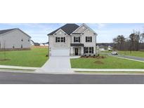 Charming two-story home featuring a brick facade, attached garage, and well-manicured lawn at 1179 Blue Juniper Cir, Loganville, GA 30052