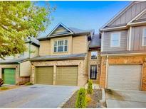 Charming two-story townhome with brick accents, a two-car garage, and a well-maintained front yard at 1239 Grampian Pass # 11, Marietta, GA 30008
