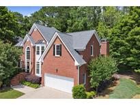 Traditional two-story brick home featuring manicured landscaping and an attached two-car garage at 220 Webley Ln, Alpharetta, GA 30022