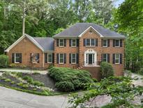 Beautiful brick home with mature trees, black shutters, and professionally landscaped front yard at 127 Roe Hampton Ln Ln, Stone Mountain, GA 30087
