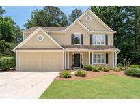Charming two-story home featuring a well-manicured lawn and an attached two-car garage at 516 Huntgate Rd, Woodstock, GA 30189
