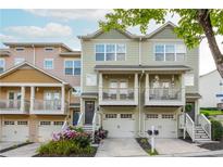 Charming townhome exterior with a two-car garage, beautiful landscaping, and inviting front porch at 1304 Liberty Nw Pkwy # 1610, Atlanta, GA 30318