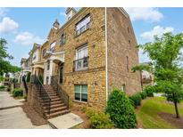 Charming brick townhome featuring a covered entryway and manicured landscaping at 4202 Morrison Way # 9, Atlanta, GA 30341