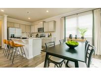 Open kitchen and dining area featuring stainless steel appliances, counter seating, and natural light at 4936 Jatoba Rd, Acworth, GA 30101