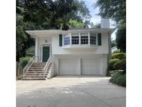 Charming home featuring a two-car garage, stone stairs, and a striking green front door at 746 Gladstone Nw Rd, Atlanta, GA 30318