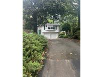 Charming two-story home featuring a two-car garage, bay window, a green front door, and mature trees at 746 Gladstone Nw Rd, Atlanta, GA 30318
