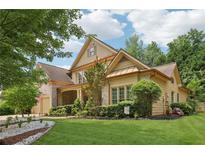 Charming two-story home with lush landscaping, brick accents, and attached two car garage at 895 Mill Garden Pl, Cumming, GA 30040