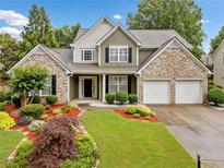 Charming two-story home featuring a brick facade, well-manicured lawn, and a two-car garage at 977 Frog Leap Trail Nw, Kennesaw, GA 30152