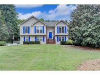 Charming two-story home featuring blue shutters and a well-manicured lawn at 1818 Mcconnell Rd, Grayson, GA 30017