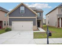 Charming two-story home with a two car garage, landscaped front yard and craftsman style accents at 2493 Oakleaf Rdg, Lithonia, GA 30058